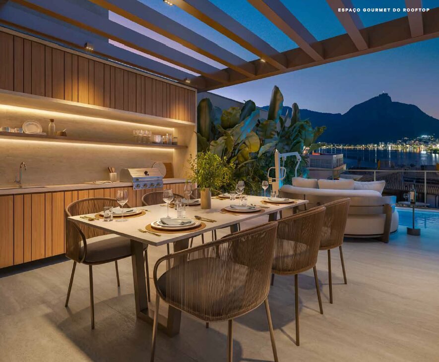 Espaço gourmet do rooftop à noite com vista para o Corcovado
