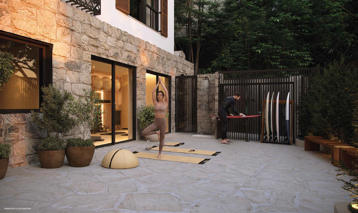 Espaço externo wellness do Stay 360 Leblon com yoga e prancheiro de surf